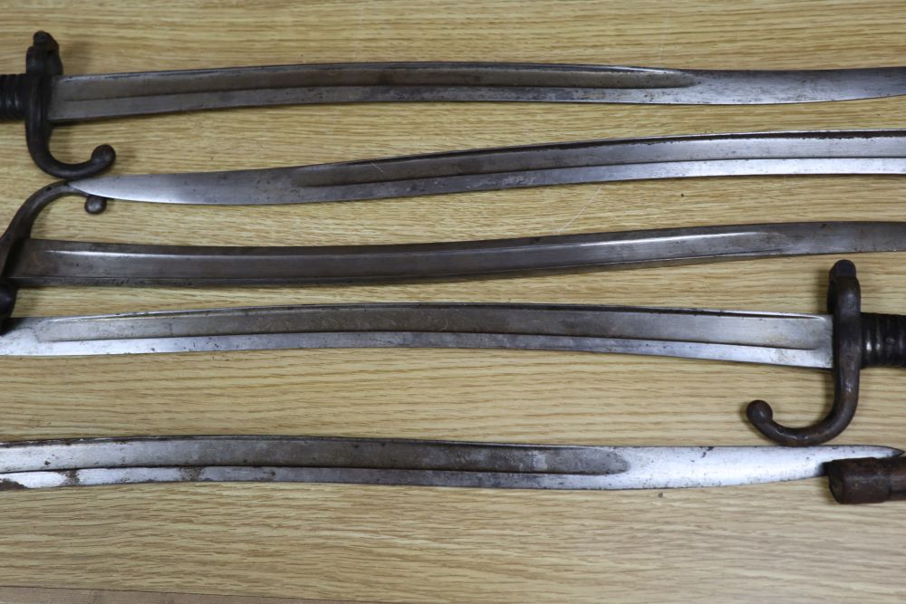 Six bayonets and two axes, largest 99cm